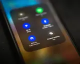 Ekran telefonu z widocznym menu, gdzie opcja AirDrop jest podświetlona. To funkcja do bezprzewodowego udostępniania plików między urządzeniami Apple.