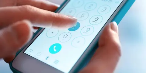 Dłoń wybiera numer na ekranie smartfona. Czy połączy się z kimś w jakiej sieci?