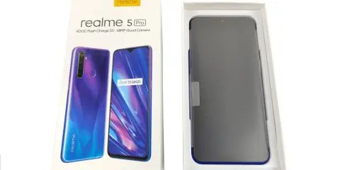 Pudełko z telefonem realme 5 Pro, z widocznym na opakowaniu modelem i specyfikacją, obok niego smartfon w opakowaniu.