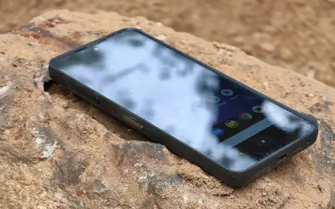 Telefon CAT najnowszy, wytrzymały, leży na kamieniu.