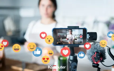 Kobieta nagrywa filmik w kuchni, a wokół telefonu unoszą się emotikony. Idealne do aplikacji do oglądania filmów i tworzenia treści.