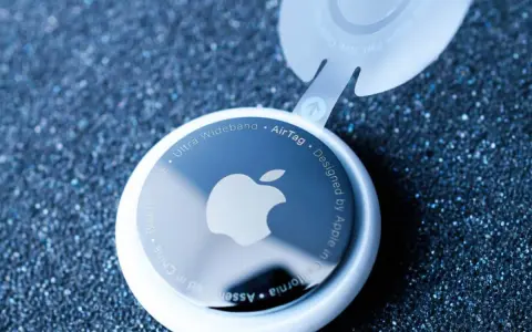 Biały AirTag z logo Apple, pokazujący, jak działa AirTag. Urządzenie z technologią Ultra Wideband.