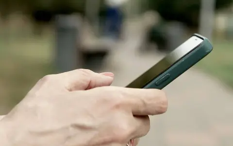 Dłoń trzyma smartfon Huawei, być może przygotowując się do wykonania hard reset.