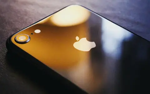 Ciemny iPhone z logo Apple. Dowiedz się, jak zmienić Apple ID, aby zabezpieczyć swoje dane.
