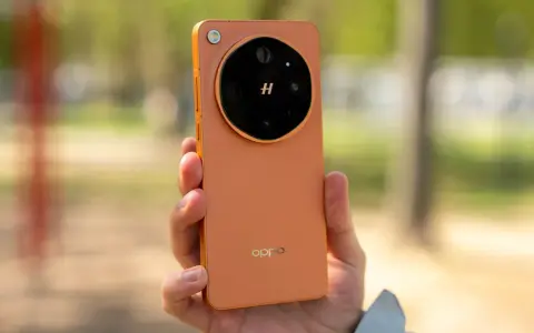 Pomarańczowy oppo flagowiec z charakterystycznym modułem aparatu w dłoni, na tle rozmytego, zielonego krajobrazu.