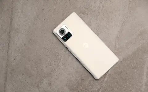 Jasny telefon Motorola edge 30 ultra z potrójnym aparatem na szarym, kamiennym tle.