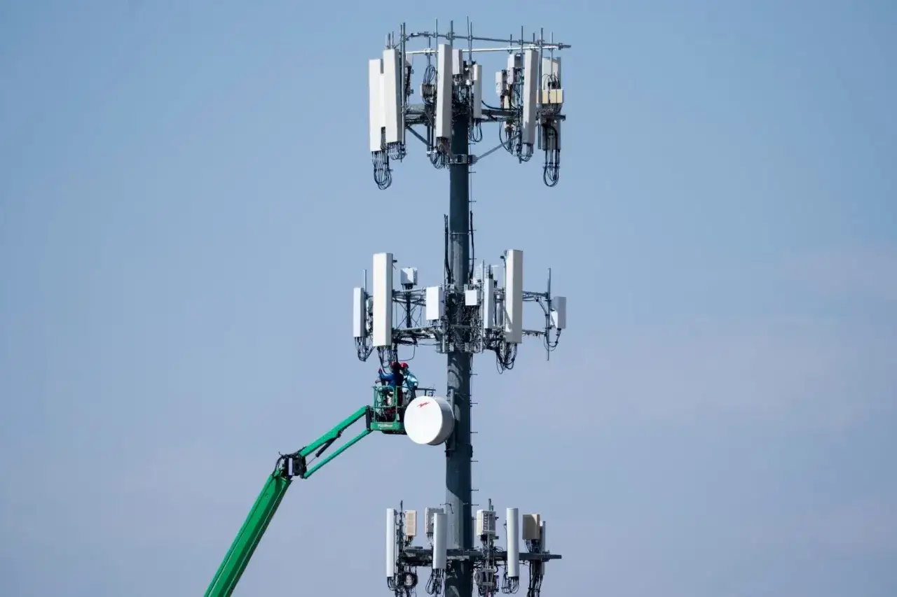 Wieża telekomunikacyjna z antenami, pracownicy na podnośniku. To właśnie dzięki takim masztom działa 5G, co to za technologia?