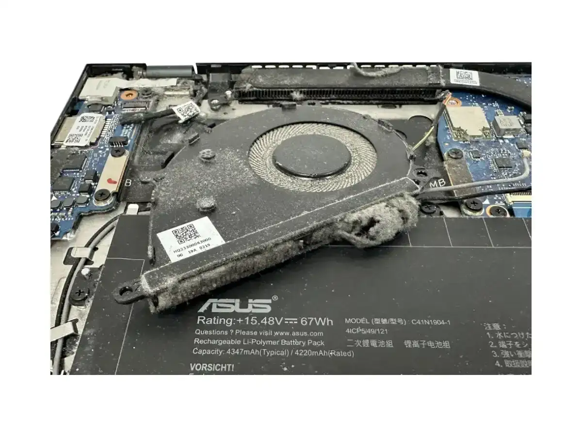 Wnętrzu laptopa ASUS widać zakurzony wentylator, kt&oacute;ry prawdopodobnie sprawia, że laptop głośno chodzi.