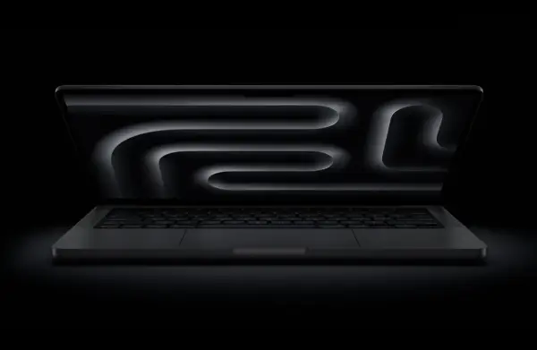 MacBook Pro z polskim układem klawiatury, ciemny ekran z abstrakcyjnym wzorem.